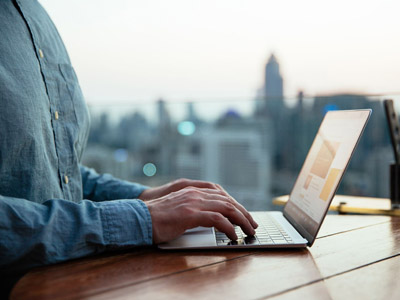 laptop on a desk with a view of the city