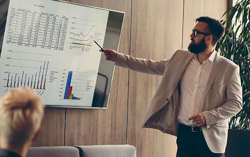 person giving a presentation with graphs on the screen