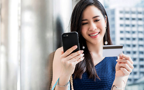 woman with her credit card and phone on her hand