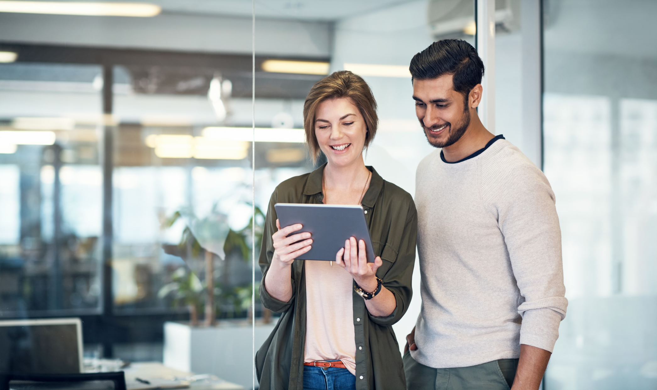 two people looking at the tablet and smiling