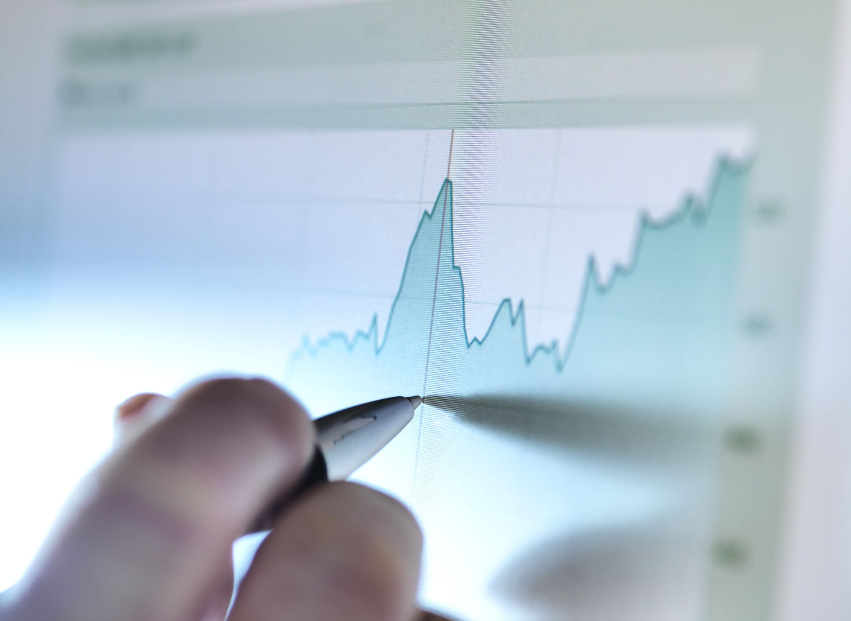 person pointing at a graph with a pen