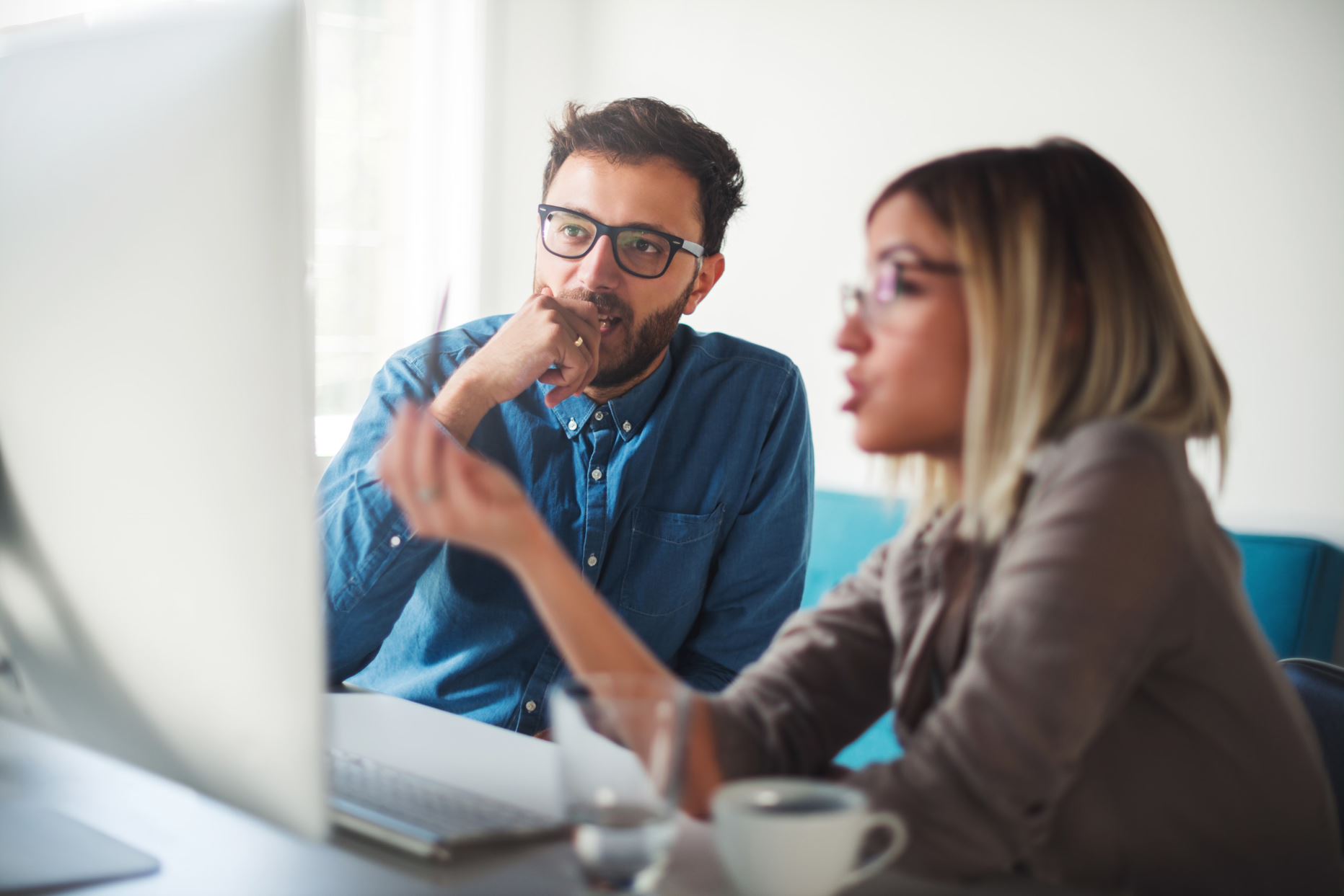 two people looking at the screen and talking