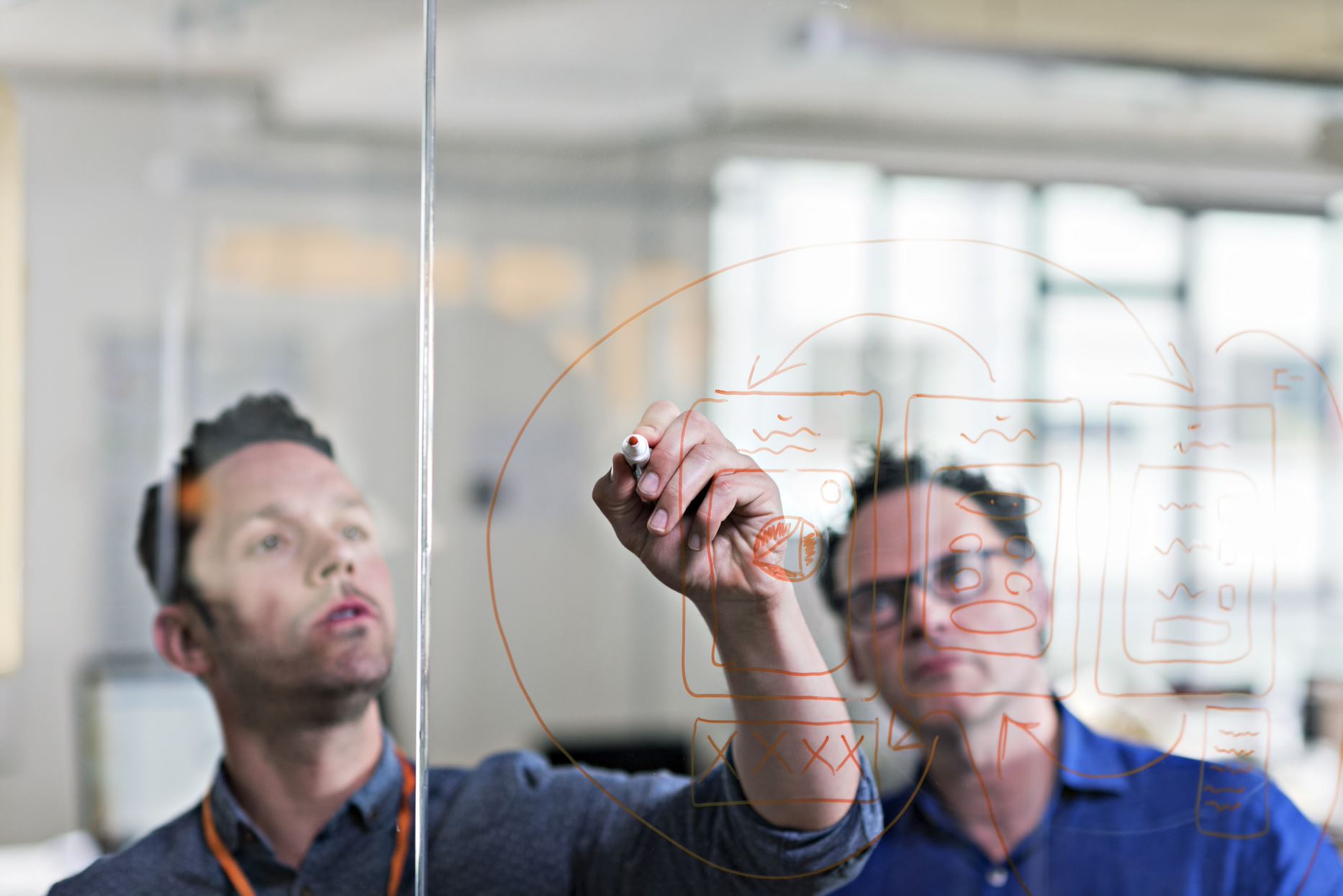 people writing something on the glass board