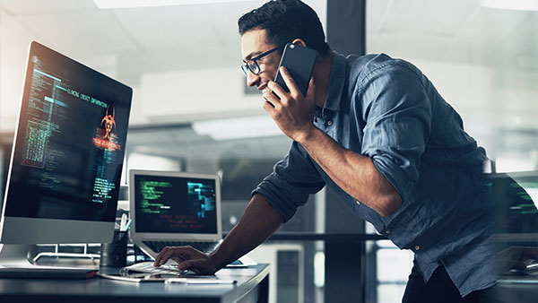 Man talking by phone and working on his pc