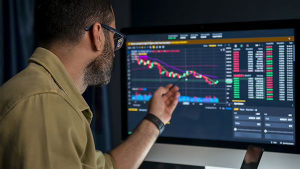 Man looking at the line graphs on the monitor