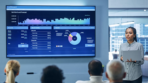 a person presenting with a screen with line/bar/pie charts