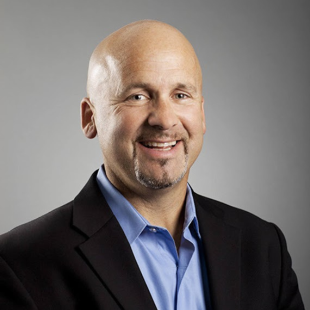 A man dressed in a suit posing for a headshot picture