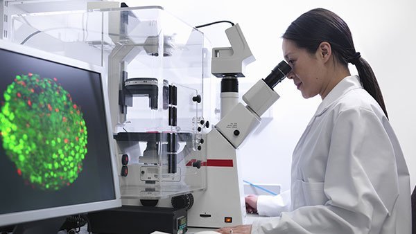 Woman looking through a microscope