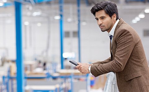 man with a phone in a factory