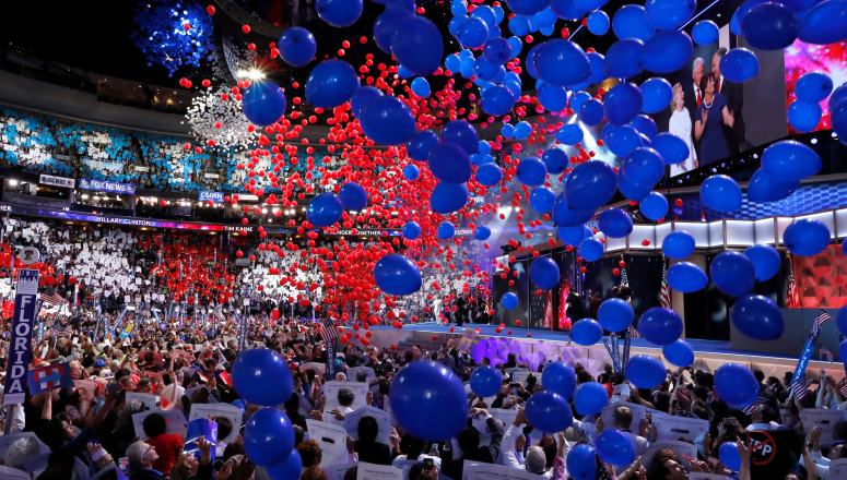 Balloons descend from the ceiling of a large arena onto a crowd of people at the 2016 Democratic National Convention in Philadelphia.