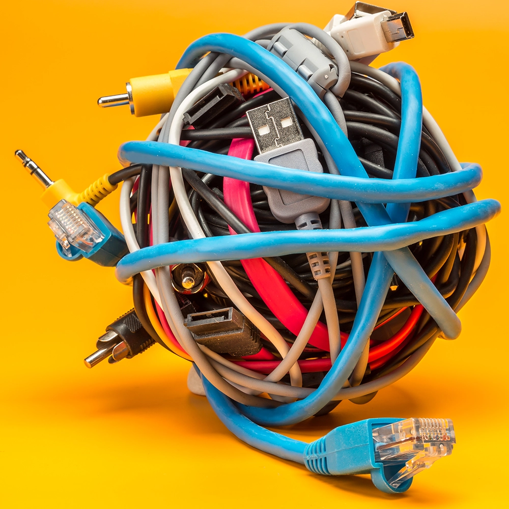 a close up of a ball made of various coloured electrical cables on a yellow background