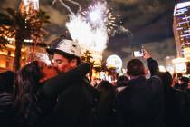 Reonna Holmes, left, kisses her boyfriend, Eric Lovato at midnight as New Year’s firewor ...