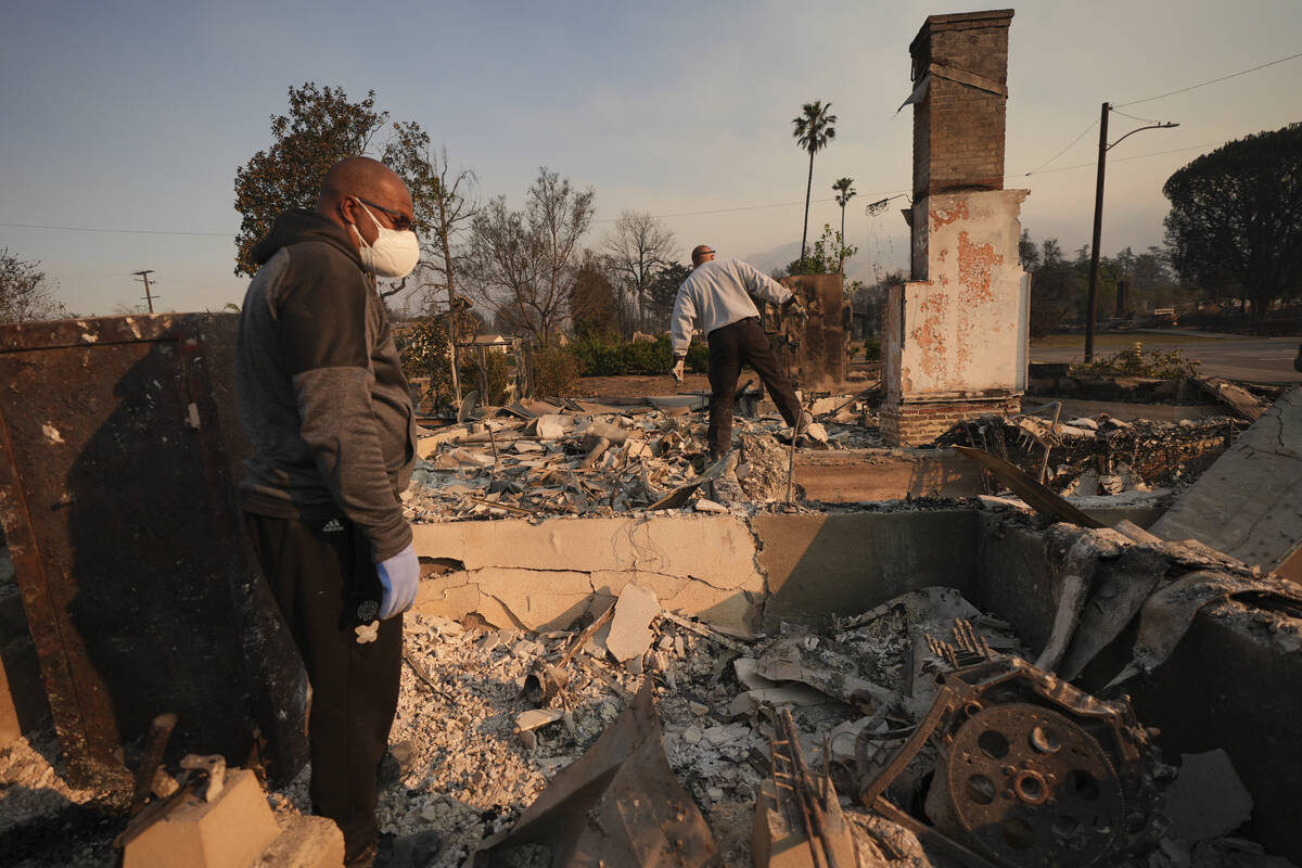 Kenneth Snowden, left, surveys the damage to his fire-ravaged property with his brother Ronnie ...