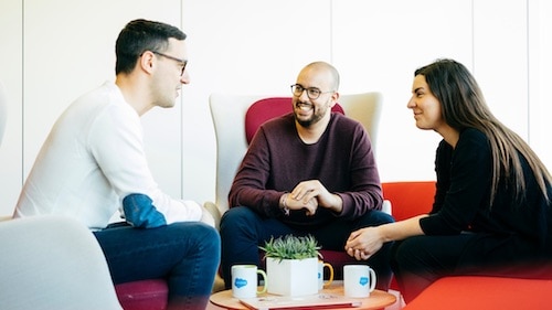 Three people sitting down to discuss small business growth strategies.