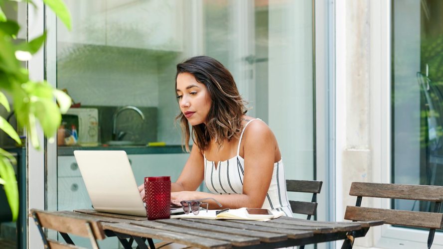 woman sitting outdoors working on a laptop: digital-first companies, digital first