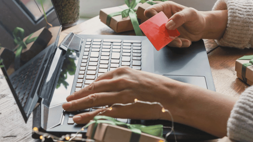 Image of woman typing credit card information on laptop / Keep Your Identity Safe This Season