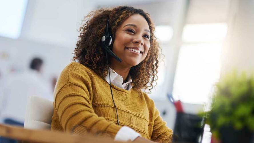 A female agent wearing a headset offers customer support.