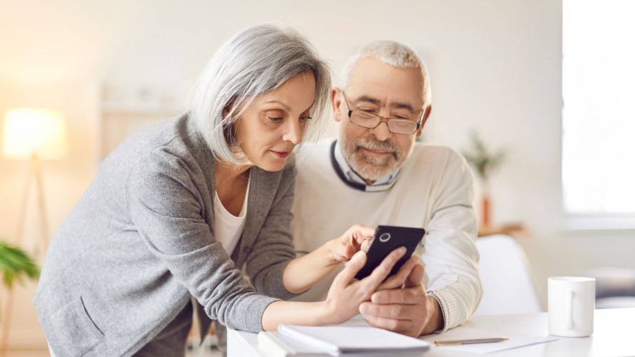 Two constituents navigate using government services on a mobile devices.