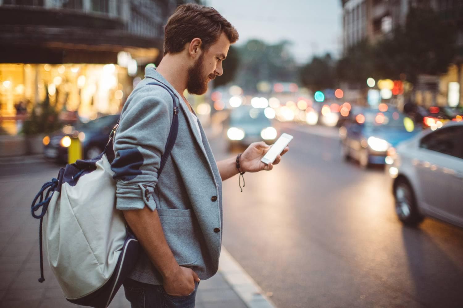 Man with backpack and mobile in a city