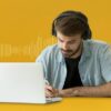 Man transcribing at desk with laptop and sound wave background