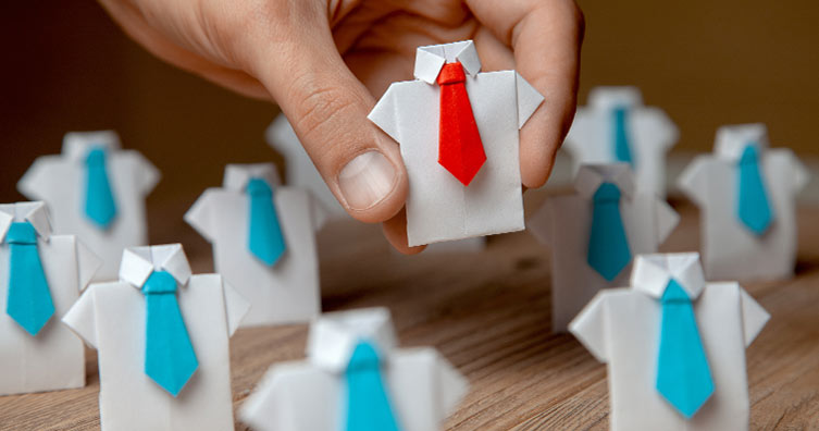 hand picking up shirt and tie made of paper