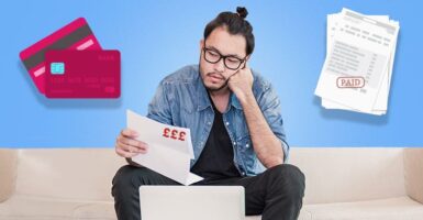 Man on sofa looking at paper with card and invoice