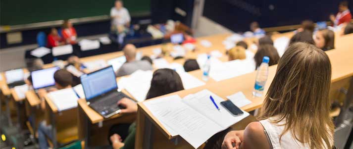 Students in a lecture hall with notes