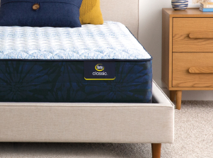 Serta classic mattress sitting in a beige bed frame.