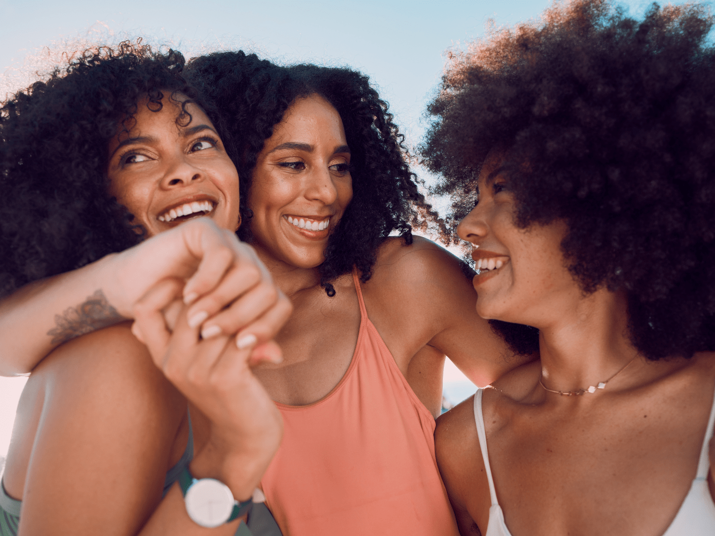 Black women holding hands and laughing