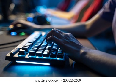 Man holding hands at computer keyboard while playing at online game during the streaming