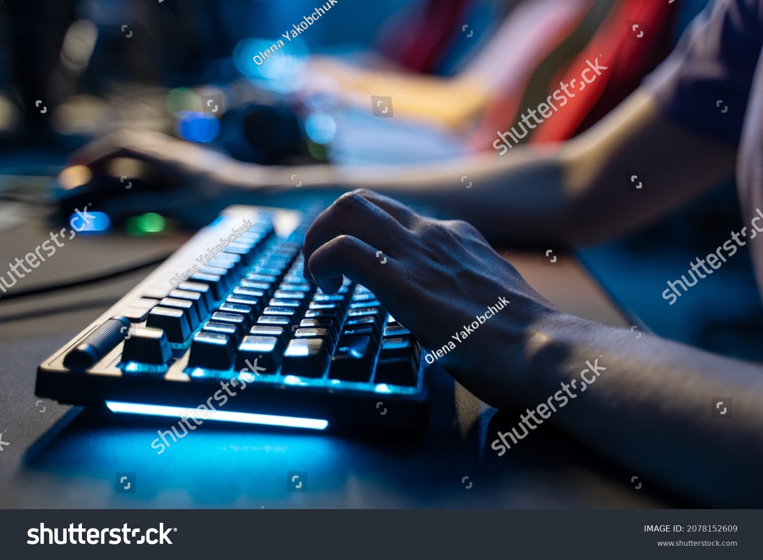 Man holding hands at computer keyboard while playing at online game during the streaming