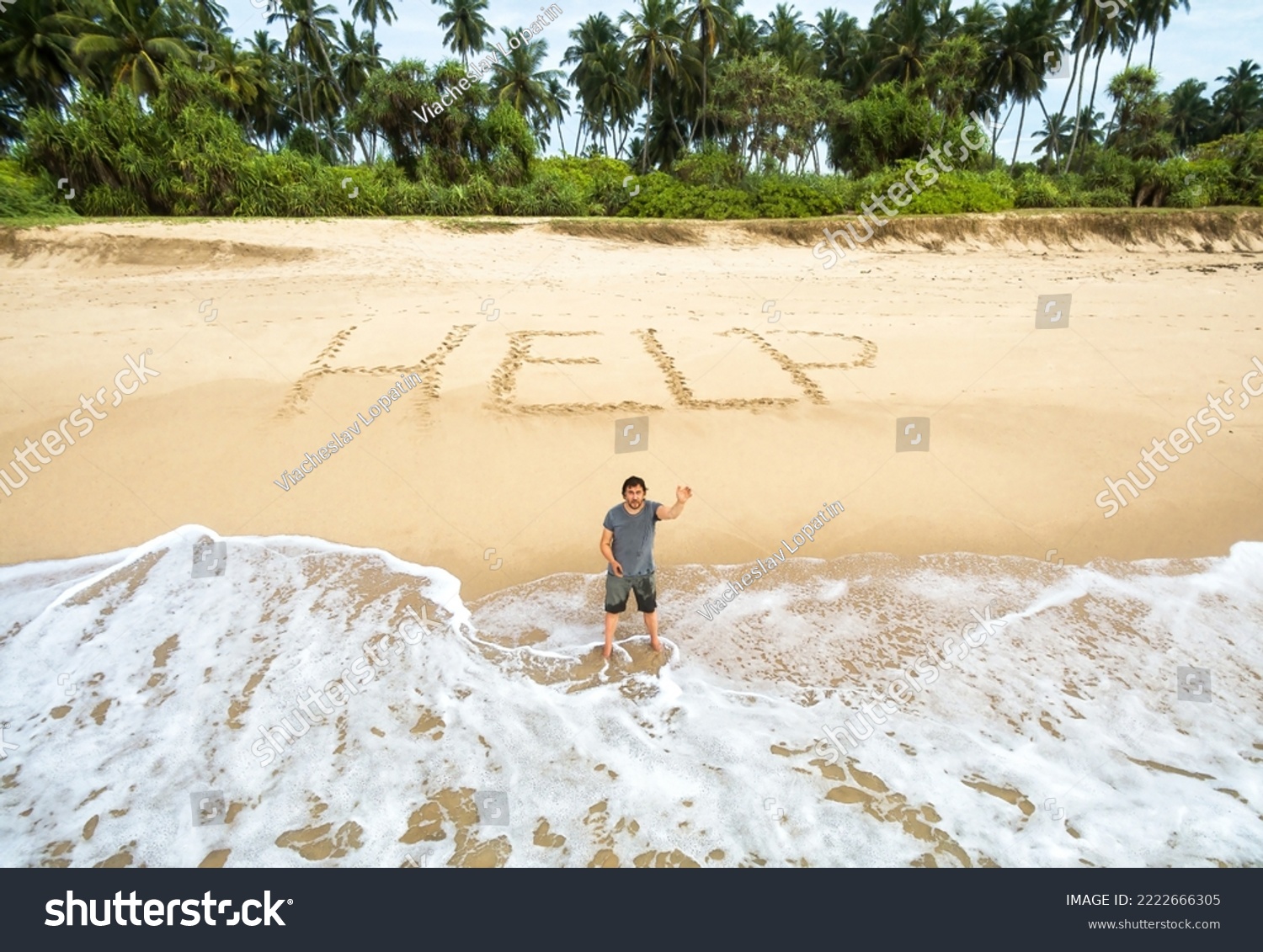 Hombre atascado en una isla deshabitada, inscripción AYUDA en la arena. Un sobreviviente solitario parado en el agua en una playa tropical desierta pide ayuda. Concepto de personas varadas perdidas, cascadas, islas marítimas y sos.