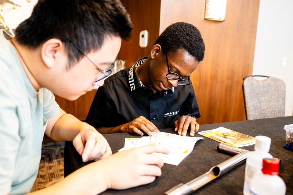 Two students sitting together reading lab materials on o table.