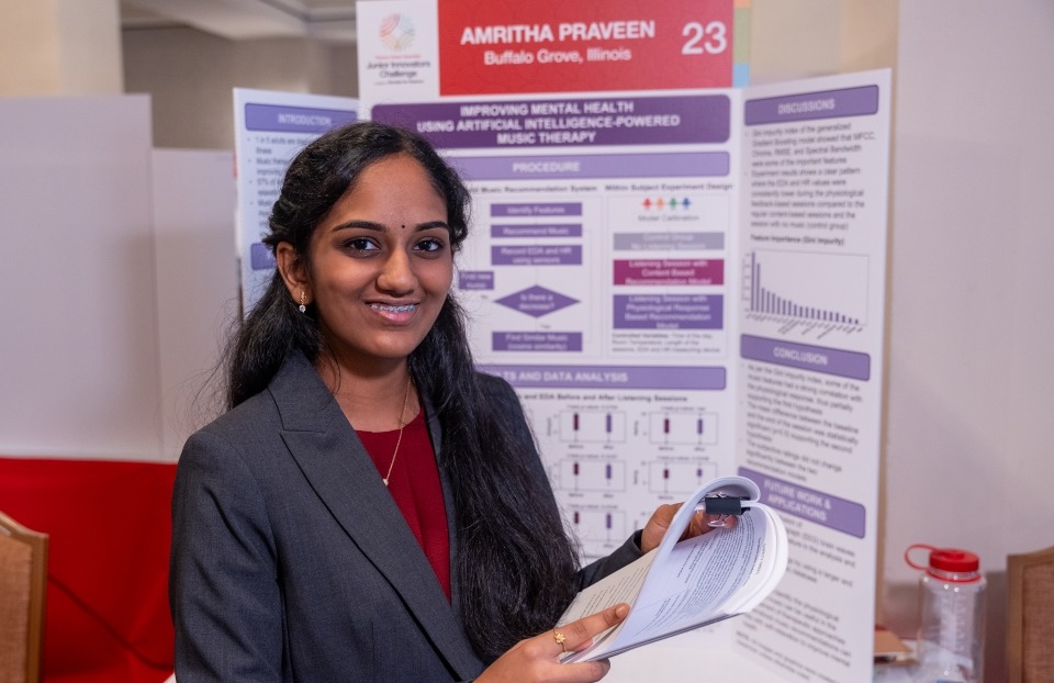 Amritha Praveen standing at her project poster