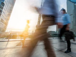 Men passing by an office building.