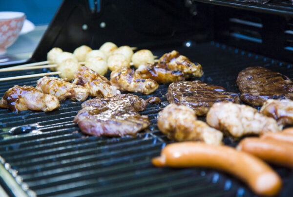 Chicken, sausage, beef and potatoes on an outdoor grill