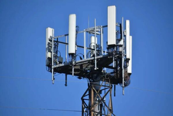 The top of a cellphone tower is seen against a blue sky