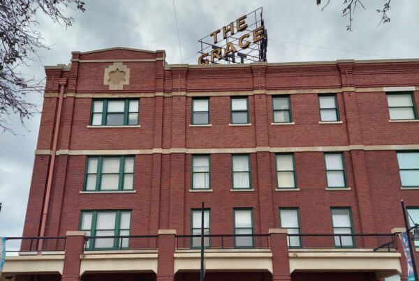 An old red brick building topped with a neon sign reading "The Grace."