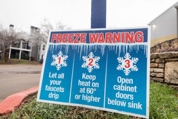 A sign outside reads "Freeze Warning: 1. Let all your faucets drip 2. Keep heat on at 60 degrees or higher 3. Open cabinet doors below sink"