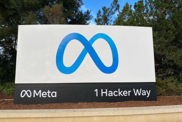 A sign with the blue Meta logo that says "Meta - 1 Hacker Way"