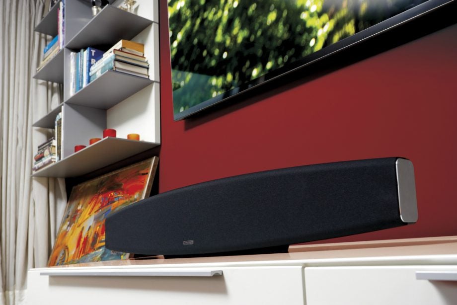 Monitor Audio ASB-2 soundbar on a white cabinet in a living room.