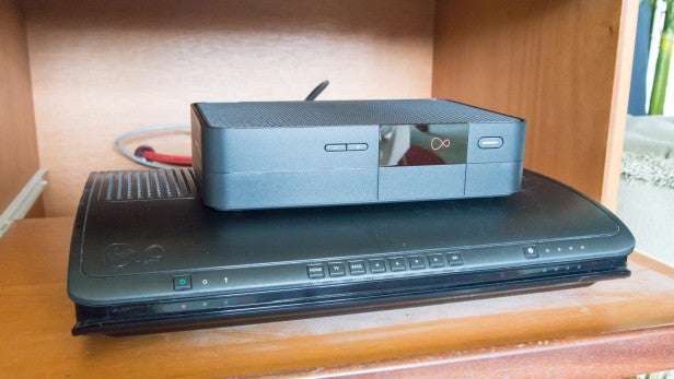 Virgin V6Virgin V6 cable box on wooden shelf with cables in background.