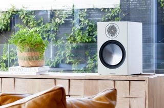 White MA Bronze 100 speaker standing on a wooden shelf