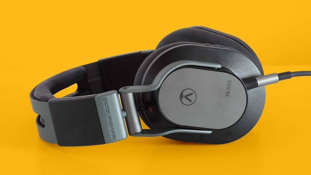 Austrian Audio Hi-X55Gray-black Hi-X55 headphones laid on a solid-yellow background