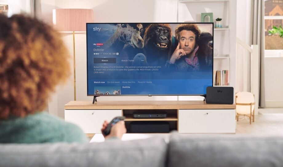 A TV standing on a wooden table, displaying main menu of Dr Dolittle on Sky-Q