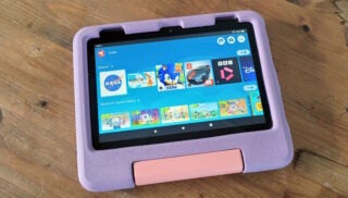 Amazon Fire HD 8 Kids tablet with purple case on wooden table.