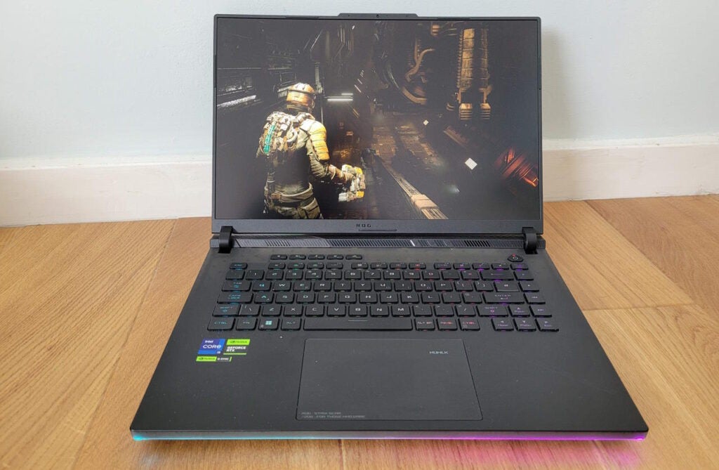 The Asus ROG Strix Scar 16 (2023) laptop with an RGB underglow.Asus ROG Strix Scar 16 laptop with game on screen.