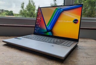 Asus Vivobook Pro 16X OLED laptop on a wooden table.