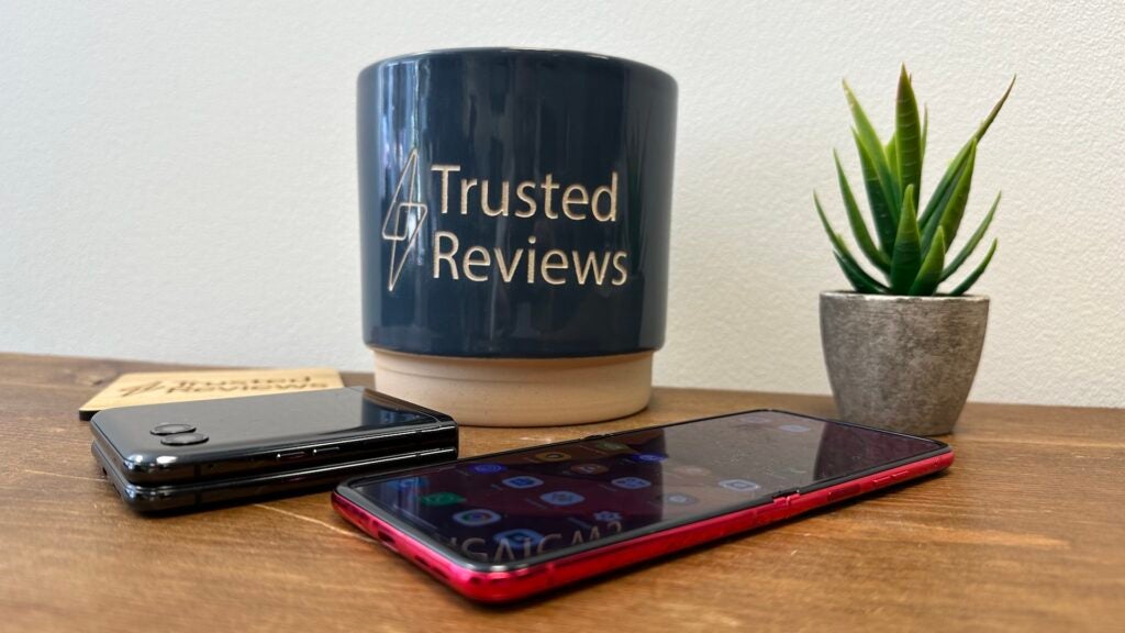 Motorola Razr 40 Ultra unfolded on a tabletMotorola Razr smartphone next to a coffee mug and plant.