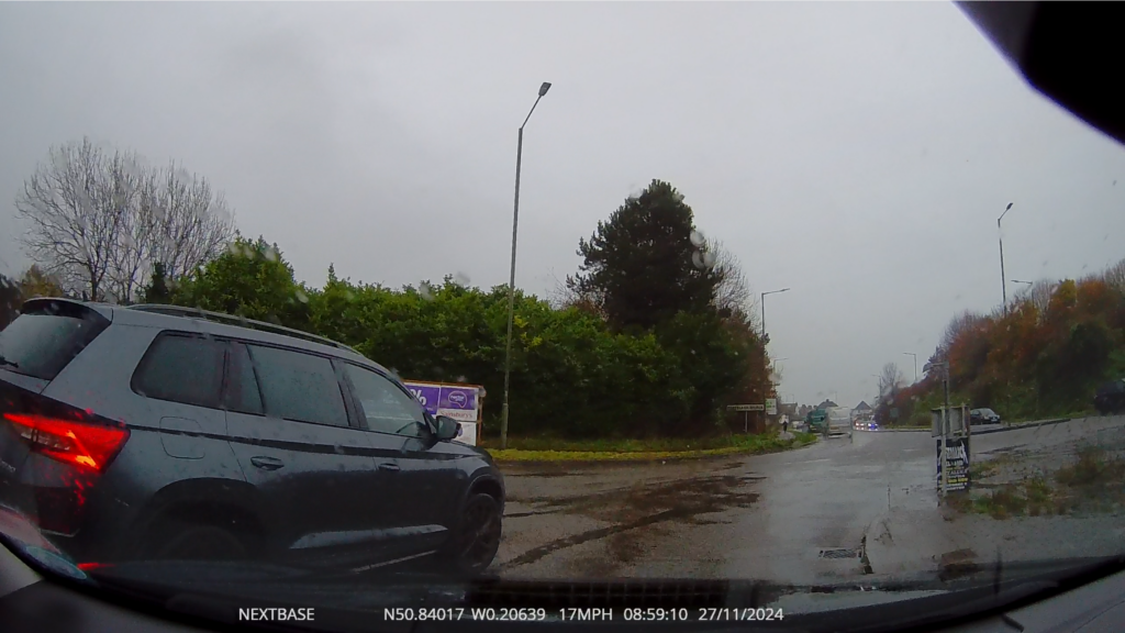 Video still-frame showing the driver being cut off in dingy, wet conditions